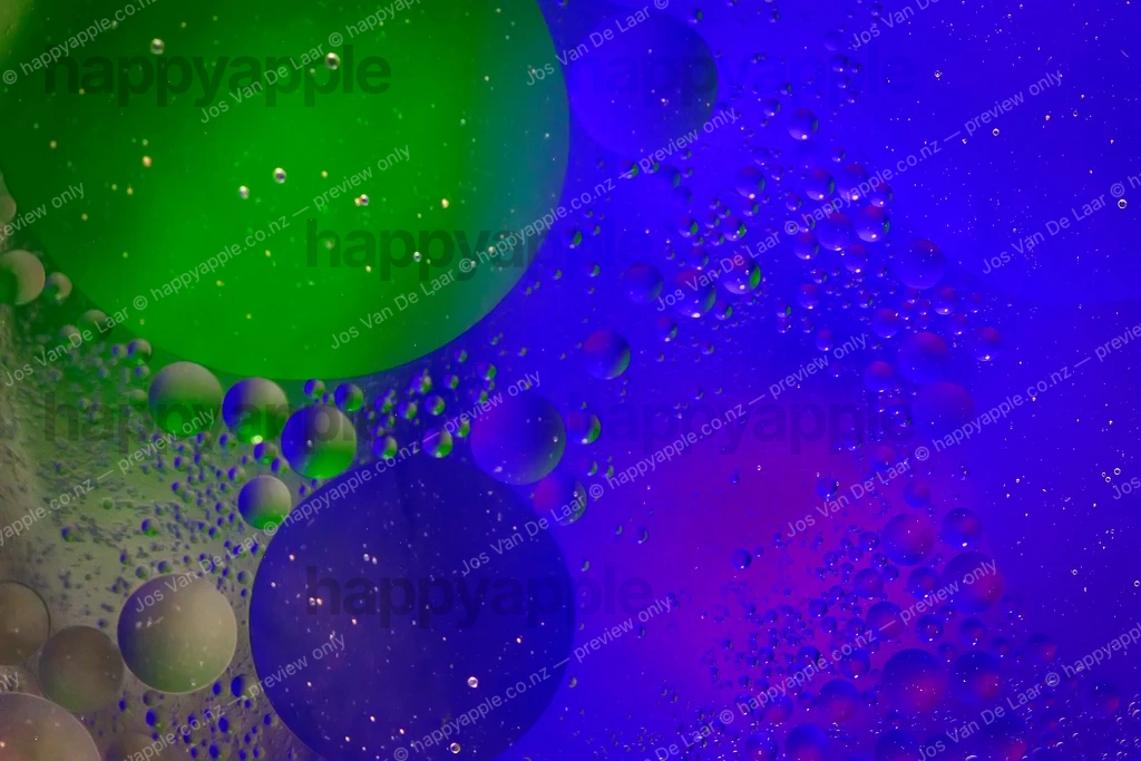 Oil and Water Bubbles Floating in Electric Blue and Green Light — Abstract photo by Jos Van De Laar