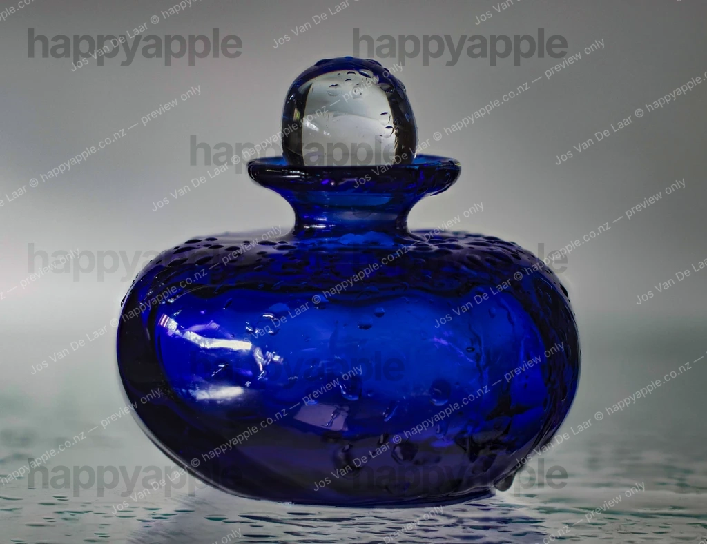 Cobalt Blue Glass Perfume Bottle Glistening with Water Droplets — Macro photo by Jos Van De Laar