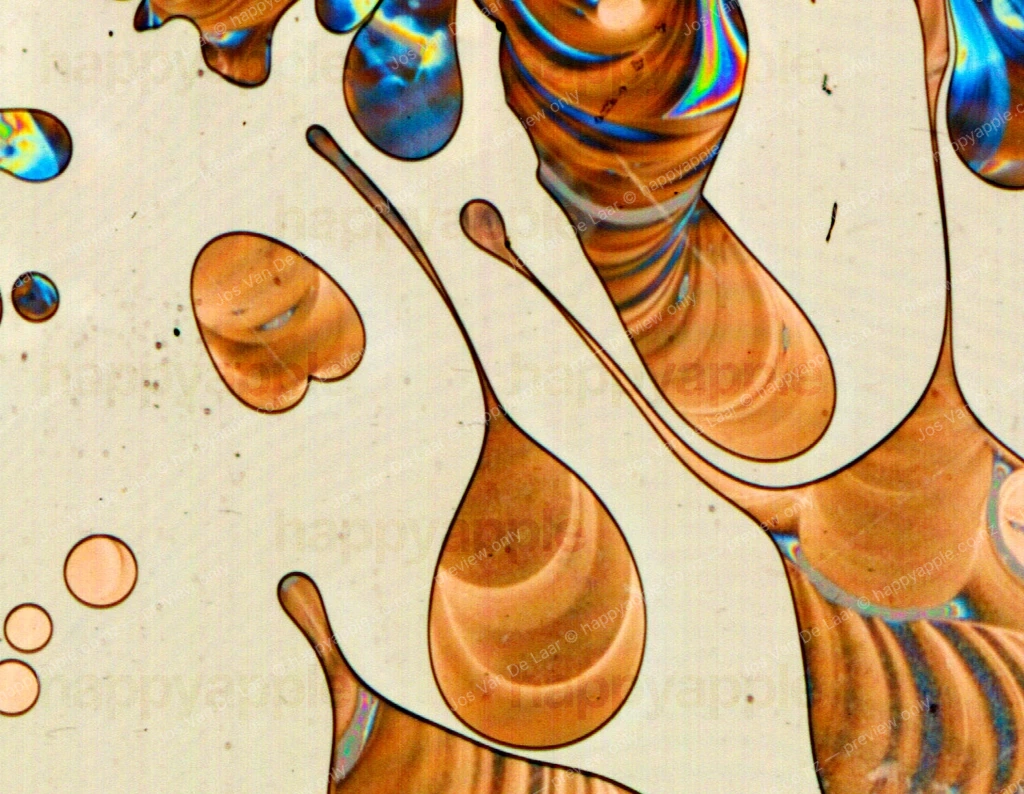 Polarized Light Reveals Flowing Amber Forms in Glass Adhesive — Macro photo by Jos Van De Laar