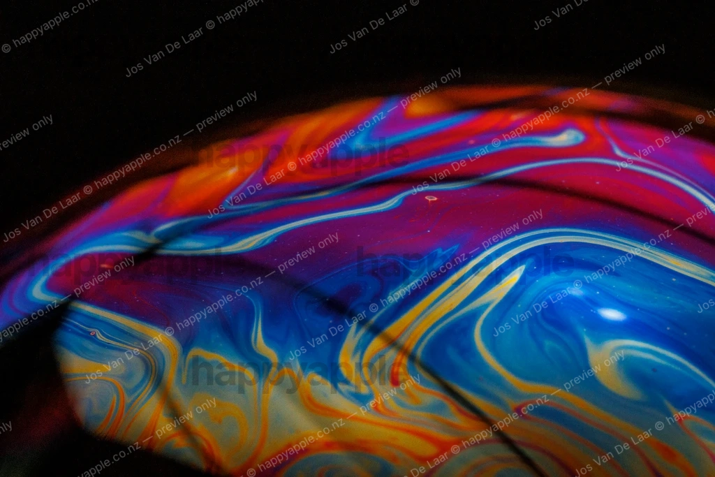 Iridescent Soap Bubble Surface — Swirling Rainbow Thin-Film Colors — Macro photo by Jos Van De Laar
