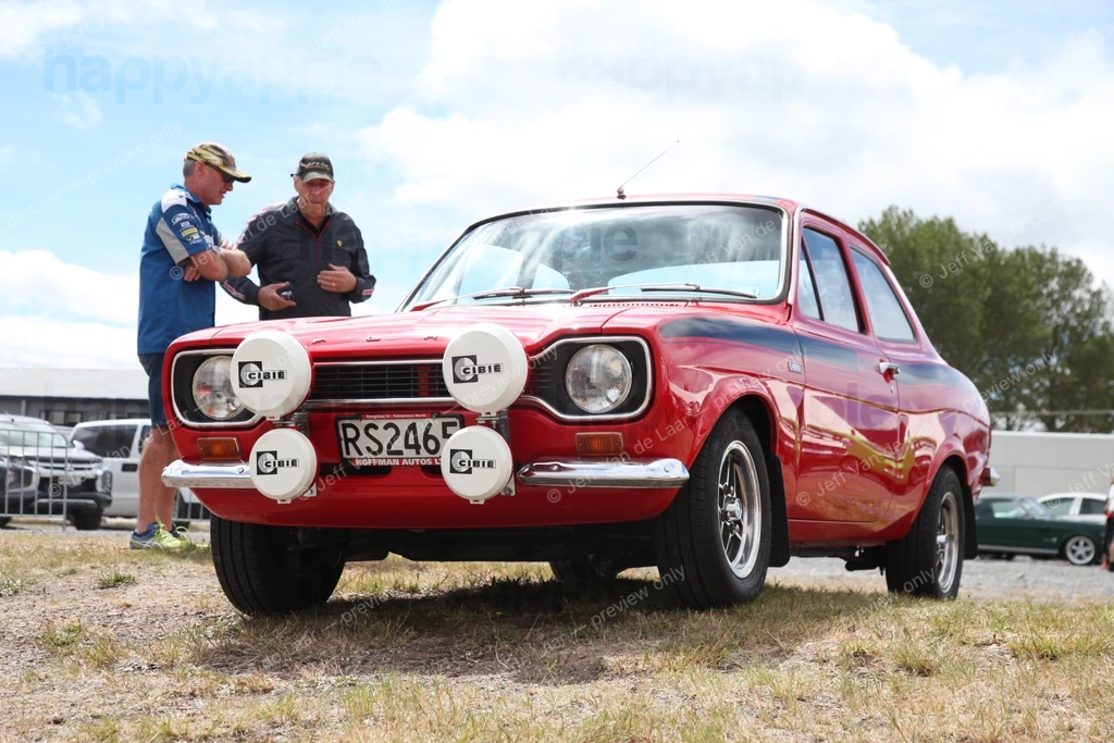 Two men inspecting a red classic rally car at an outdoor event — Automotive photo by Jeff Van de Laar