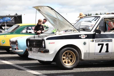 Classic rally car number 71 at a motorsport event paddock