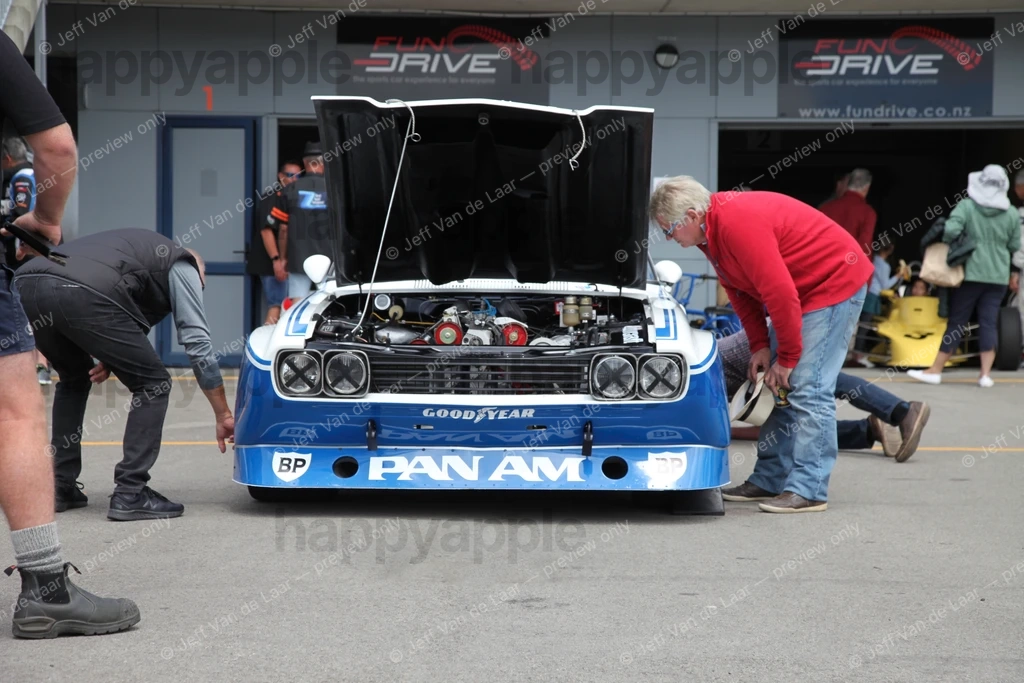 Vintage racing car with open bonnet inspected by mechanics in pit lane — Automotive photo by Jeff Van de Laar
