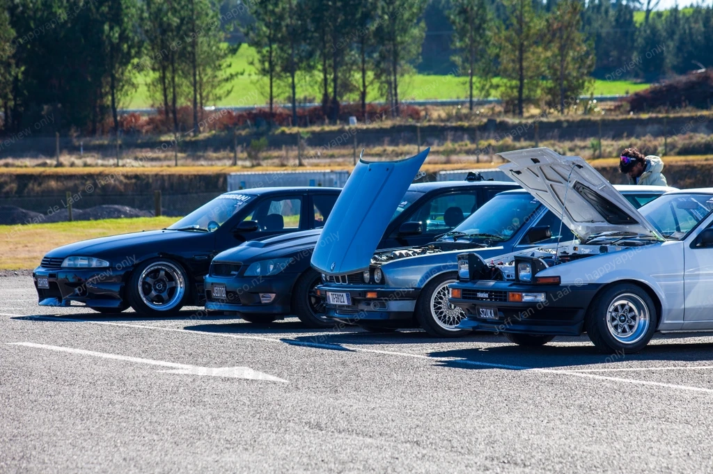 Three modified cars with hoods open parked at a motorsport event — Automotive photo by Jeff Van de Laar